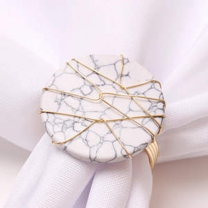 Handmade marble napkin ring with gold copper wire wrap on white fabric napkin