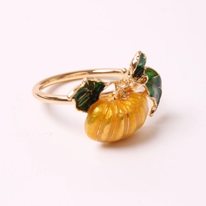 Golden pumpkin napkin ring with yellow enamel and green leaf for autumn table decor