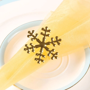 Close-up of golden snowflake napkin ring with metallic mirror finish on dining table