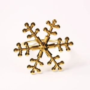 Detailed close-up of a glossy gold snowflake napkin ring on a white background