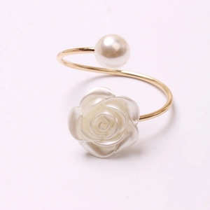 Elegante anillo de metal dorado con perla blanca y detalle de flor de resina