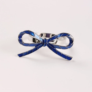 Elegant silver napkin ring with a navy blue enamel bow featuring diamond pattern texture
