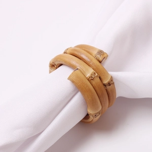 Rond de serviette en bambou naturel avec design à triple spirale sur tissu blanc