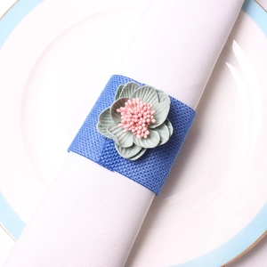 Rond de serviette avec fleur en tissu vert et base en lin bleu pour décor de table