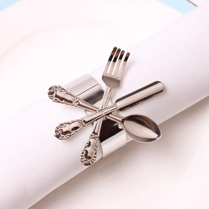 Polished silver metal napkin ring featuring miniature cutlery design on white napkin
