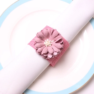 Gros plan d'un rond de serviette en lin avec une fleur de marguerite faite à la main