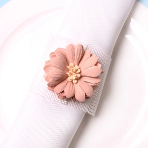 Détail macro du rond de serviette en fleur de tissu rose vintage aux pétales doux