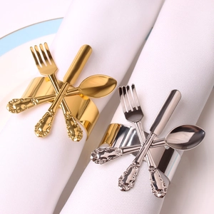 Close-up of gold and silver metal napkin rings with vintage embossed cutlery design