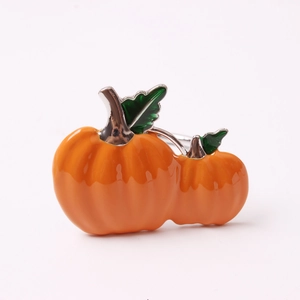 Halloween pumpkin napkin ring with orange enamel finish and green leaf details