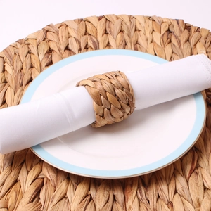 Close-up of handmade woven grass napkin ring with natural texture on a ceramic plate