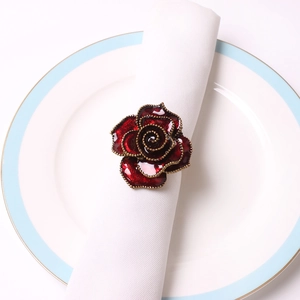 Red rose napkin ring with golden bead edges on white napkin for wedding table decor