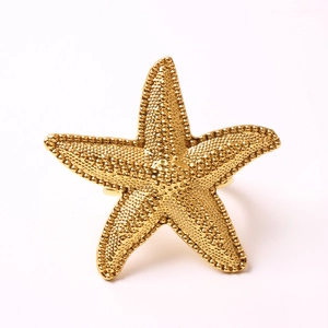 Macro shot of gold starfish napkin ring with realistic caviar texture and shiny finish