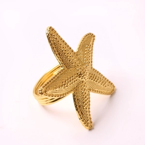 Golden starfish metal napkin ring with textured finish and spiral band design