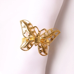 Detailed view of hollow gold butterfly napkin ring on white fabric for wedding decor