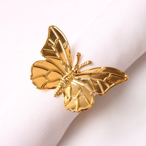 Close-up of golden butterfly napkin ring featuring detailed wing texture and metallic finish
