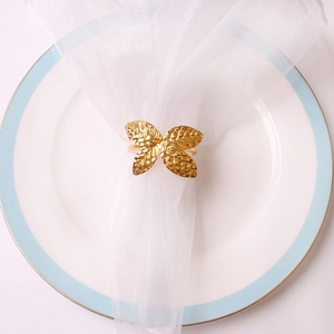 Vue de dessus d'un rond de serviette doré texturé sur une assiette en céramique