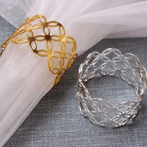 Detailed macro view of geometric floral hollow napkin rings in gold and silver finish