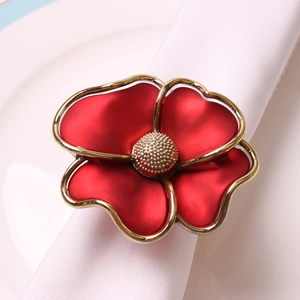 Elegant red flower napkin ring with gold edges on white napkin and ceramic plate