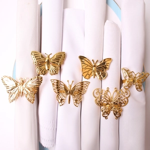Detailed view of 6 gold plated butterfly napkin rings with intricate hollow designs