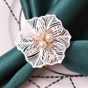 Elegant white flower napkin ring with pearls and rhinestones on a green silk napkin