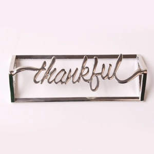 Macro detail of silver thankful napkin ring with elegant metallic hollow lettering