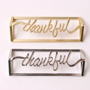 Golden and silver metal thankful napkin rings with elegant cursive lettering in frames
