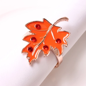 Orange maple leaf napkin ring with red rhinestones on white napkin for table decor