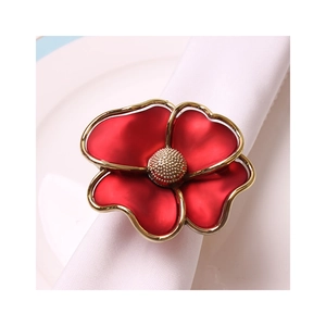 Elegant red flower napkin ring with gold trim and textured core on white fabric