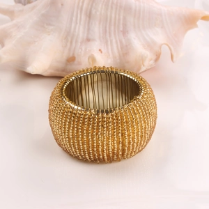 Detailed view of handmade golden beaded napkin ring with intricate woven craftsmanship