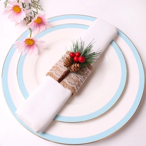 Christmas napkin ring with pine cones and red berries on a burlap and lace band