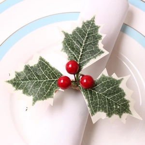 Close-up of Christmas napkin ring with red berries, green leaves and rustic woven loop