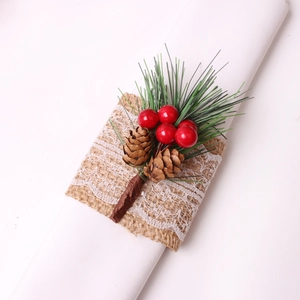 Christmas napkin ring with pine cones, red berries, and pine needles on burlap lace base