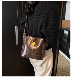 Détail du sac seau vintage en cuir marron avec fermoir doré et bandoulière