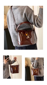 Détail d'un sac seau marron foncé brillant avec finition polie et boucle en métal