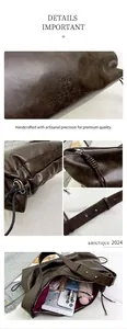 Detail of vintage brown leather bag with metallic rivets and embossed brand logo