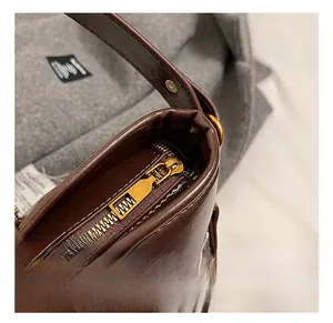 Gros plan d'un sac en cuir marron café avec des détails de fermeture éclair dorée chic