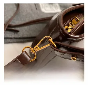 Détails du cuir brillant marron foncé avec ferrures dorées vintage et coutures