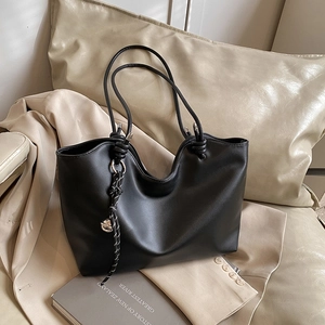 Vintage black faux leather tote bag with knot handles and woven rope details for women