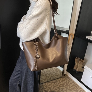 Minimalist vintage dark brown leather tote bag with stylish braided charm and metal ball