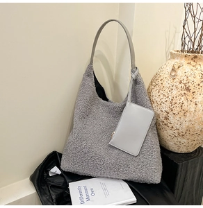 Détail du sac hobo en peau de mouton grise avec petit porte-monnaie sur fond en cuir
