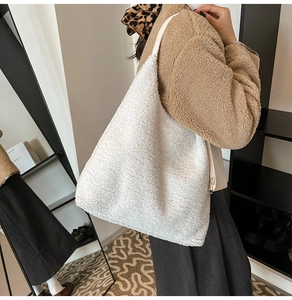 Close-up of fluffy white fleece tote bag with smooth shoulder strap on model