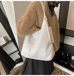 Detailed texture of white plush tote bag with matching small zipper pouch for winter