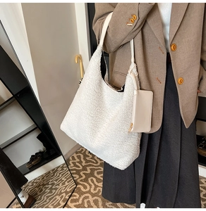 Detail of white faux shearling tote bag with a small matching leather zipper pouch