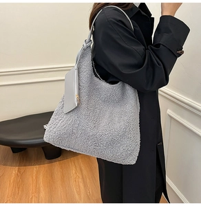 Detailed texture of grey faux shearling tote bag with matching plush zipper pouch charm