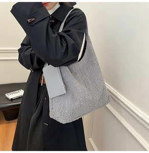 Detail of grey fleece hobo bag with leather strap and matching small zipper pouch