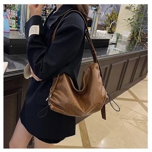 Detail of vintage dark brown hobo bag with drawstring sides and smooth leather texture