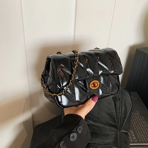 Sac bandoulière matelassé en cuir noir avec chaîne dorée et fermoir métallique rond