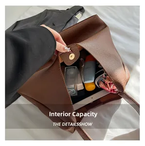 Macro view of brown lychee grain leather tote bag showing large capacity and magnetic closure