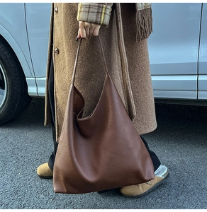 Close-up of a large dark brown leather tote bag with pebble grain texture for daily work