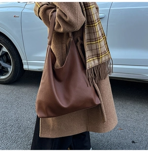 Dark brown leather hobo bag for women shown in a street scene with warm autumn tones